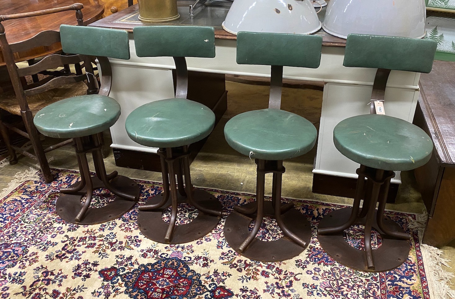 A set of four industrial style swivel stools, height 83cm